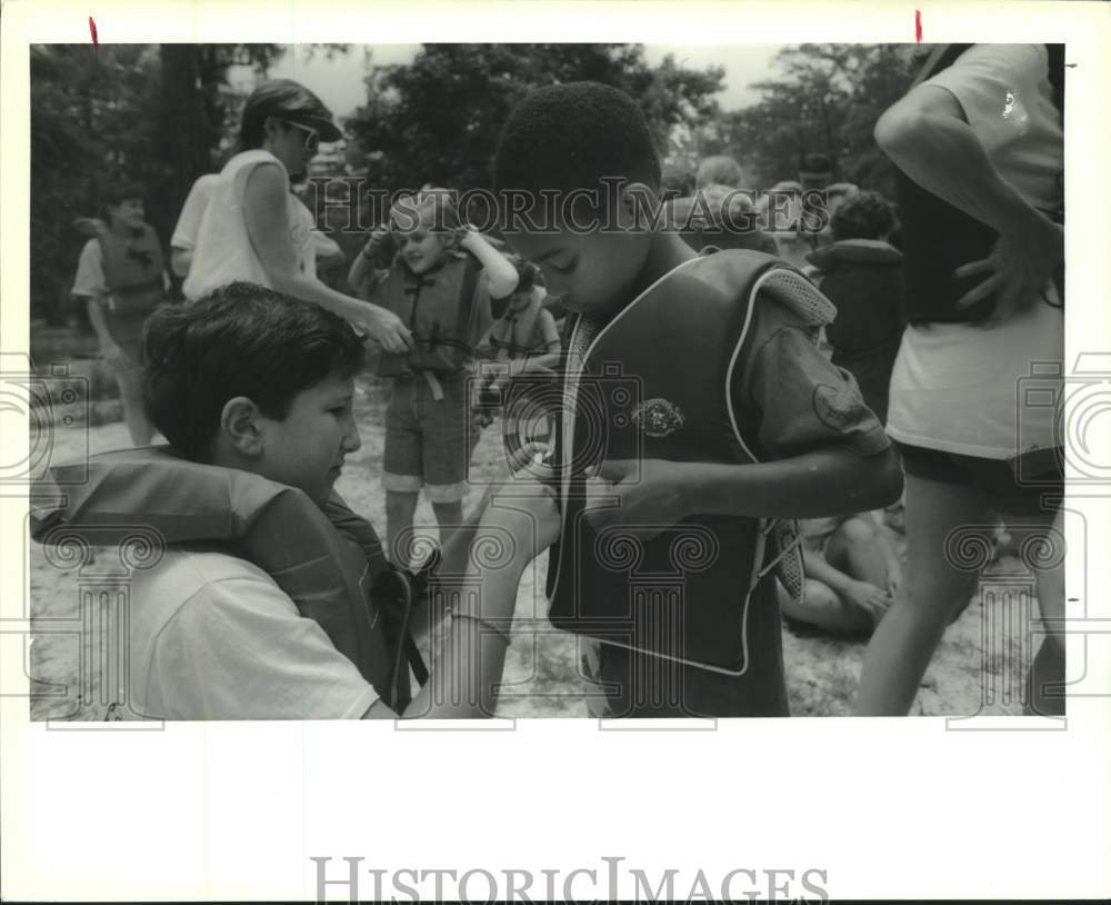 1990 Press Photo Jim Mayfield helps Cedric Vick with his life jacket before trip - Historic Images