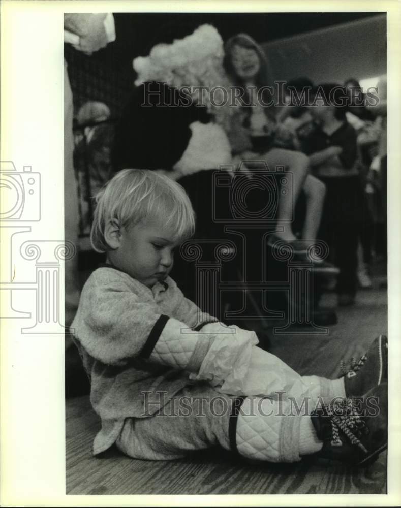 1991 Press Photo Justin Keen digs in his bag from Santa Claus at Abita town hall - Historic Images