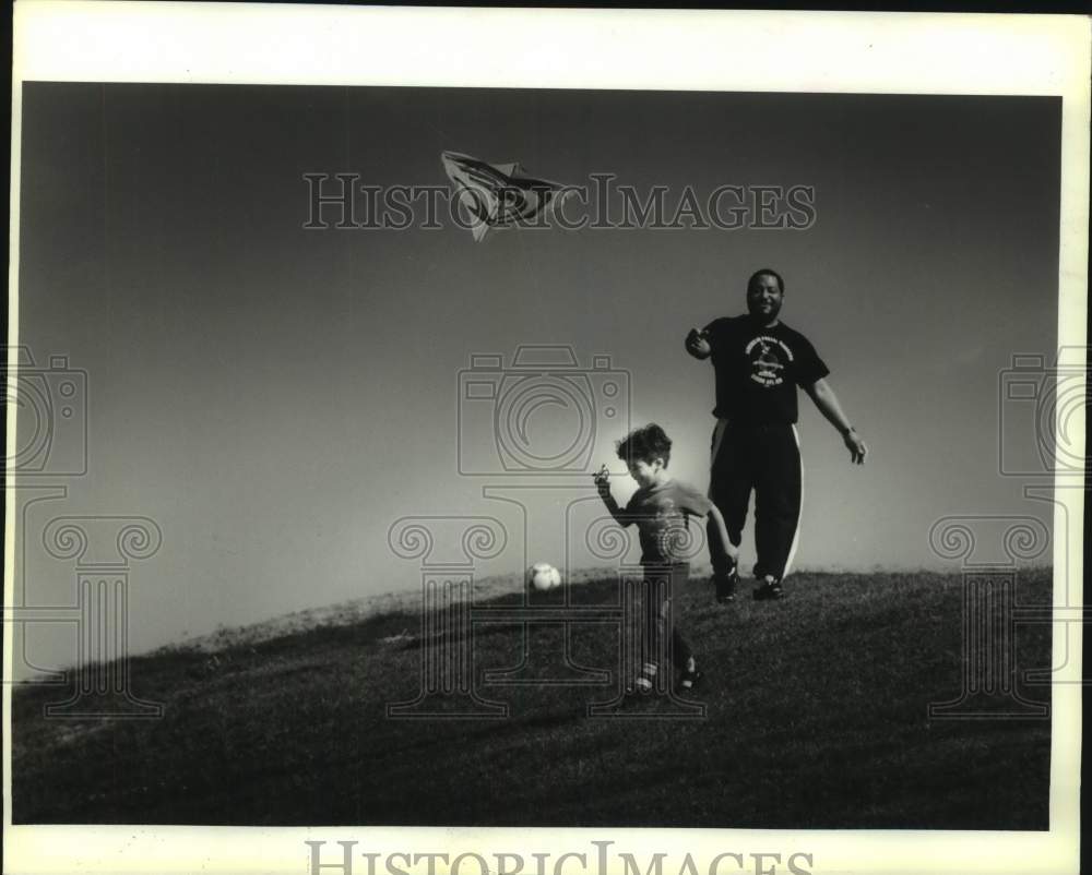 1994 Press Photo Cesar Cruz and son Justin, kite in tow at Lafreniere Park - Historic Images