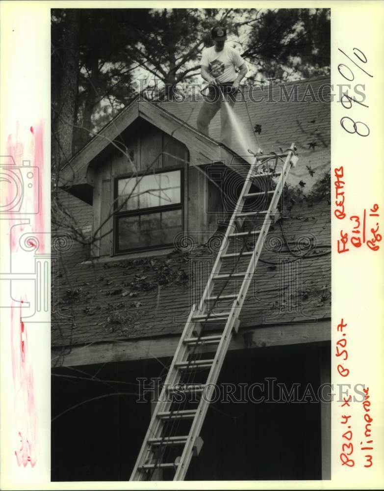 1993 Press Photo Joe Vendetti using high pressure hose to blow leaves off roof - Historic Images