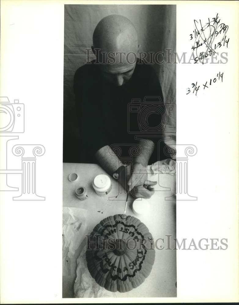 1990 Press Photo Artist Martin Laborde paints a pumpkin at the French Market - Historic Images