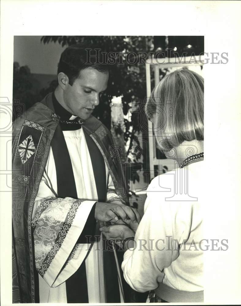 1987 Press Photo Lynn Mauney gets her hand annointed by Father Jose Lavastida - Historic Images