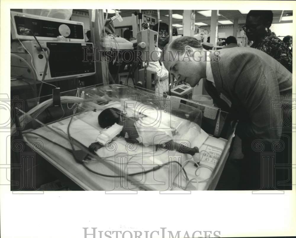 1994 Press Photo Mitch Landreau looks at premature baby at Charity Hospital - Historic Images