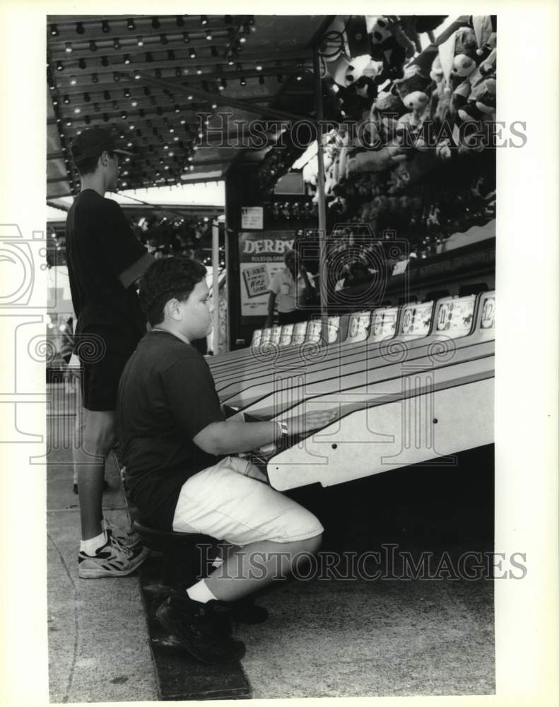 1994 Press Photo Malcolm LeBlanc plays a carnival game at Seafood Festival. - Historic Images