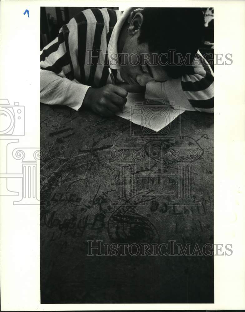 1987 Press Photo Sean Wallace works on paper in civics class-Edna Karr Jr High - Historic Images