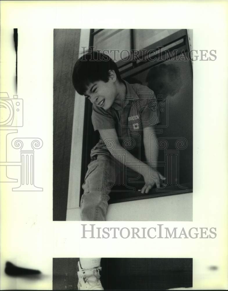 1990 Press Photo Matthew Jobin of Arden Cahill Academy is helped out a window - Historic Images