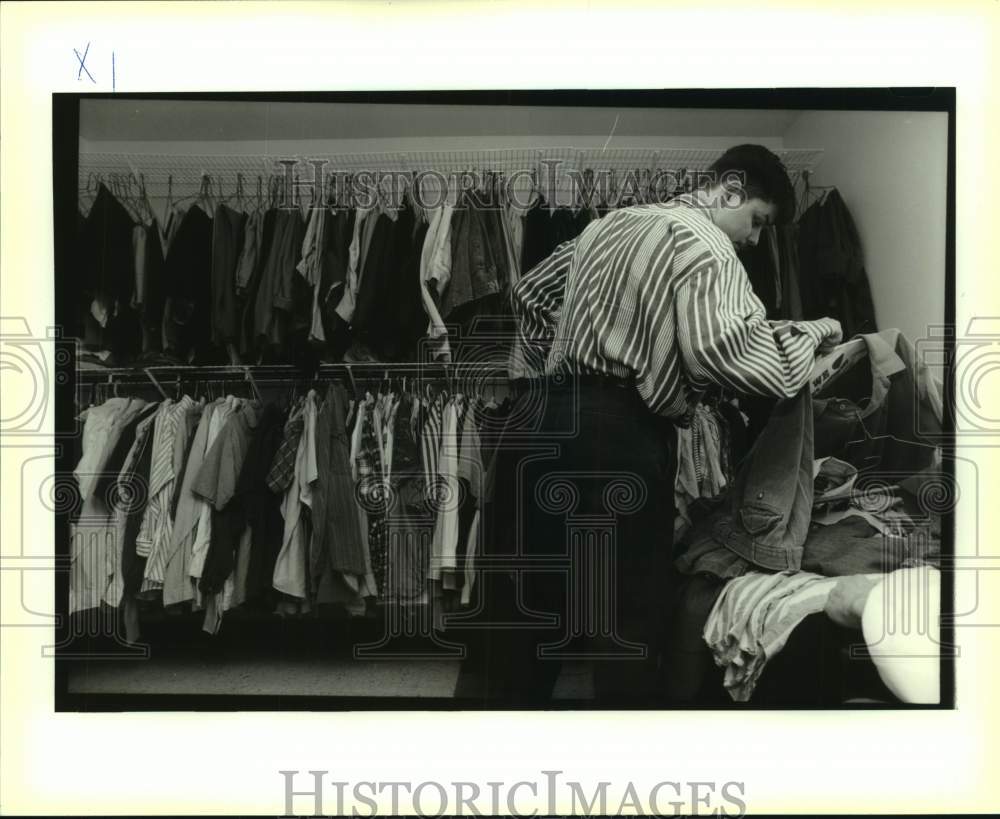 1995 Press Photo Billy Homan Jr. sorts through some cloths at Hope Haven Center - Historic Images