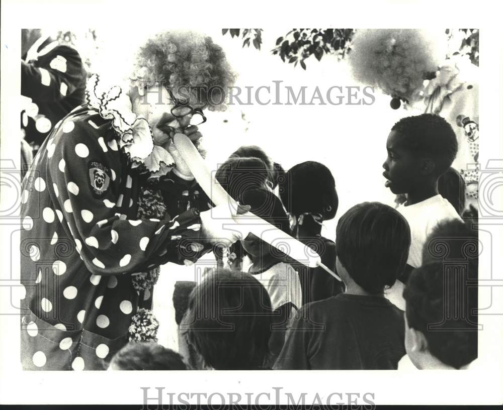 1987 Press Photo Jerusalem Temple Clown Poopsie makes a balloon animals for kids - Historic Images