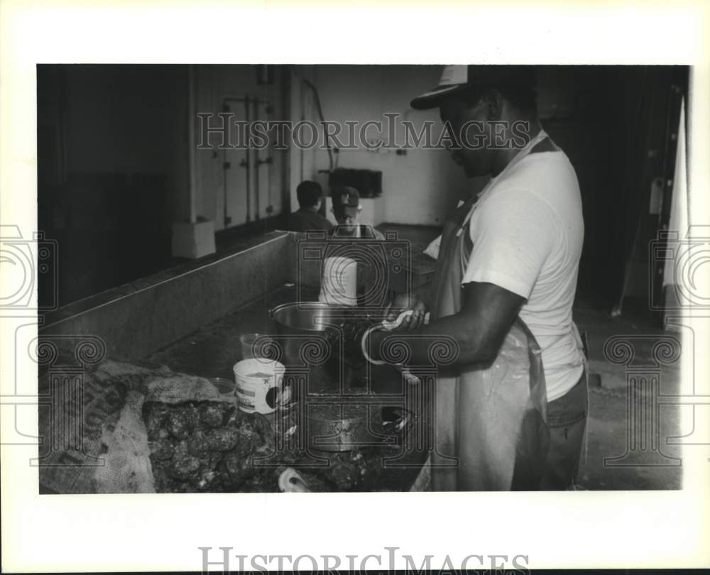 1993 Press Photo Amos Martin shuck oyster at P.J.s&#39; seafood market - Historic Images