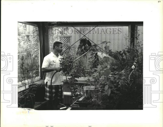 1992 Press Photo Volunteer Earl Williams waters plants, Louisiana Science Center - Historic Images