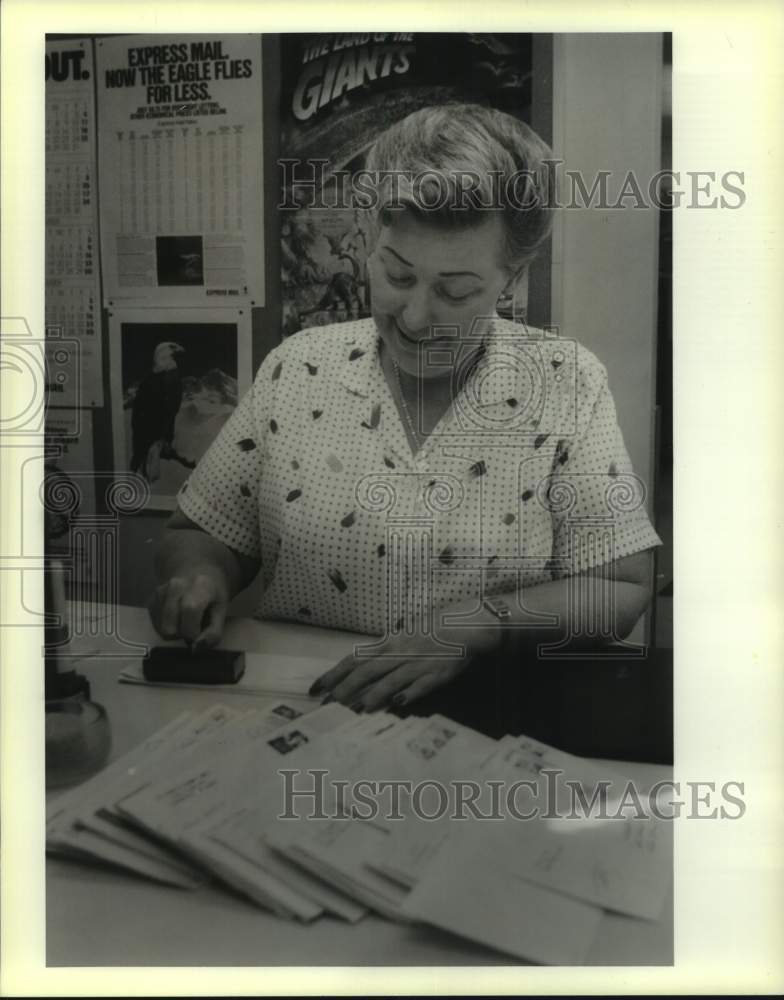 1989 Press Photo Abita Springs Postmaster Mary Lock ses a Water Festival stamp - Historic Images