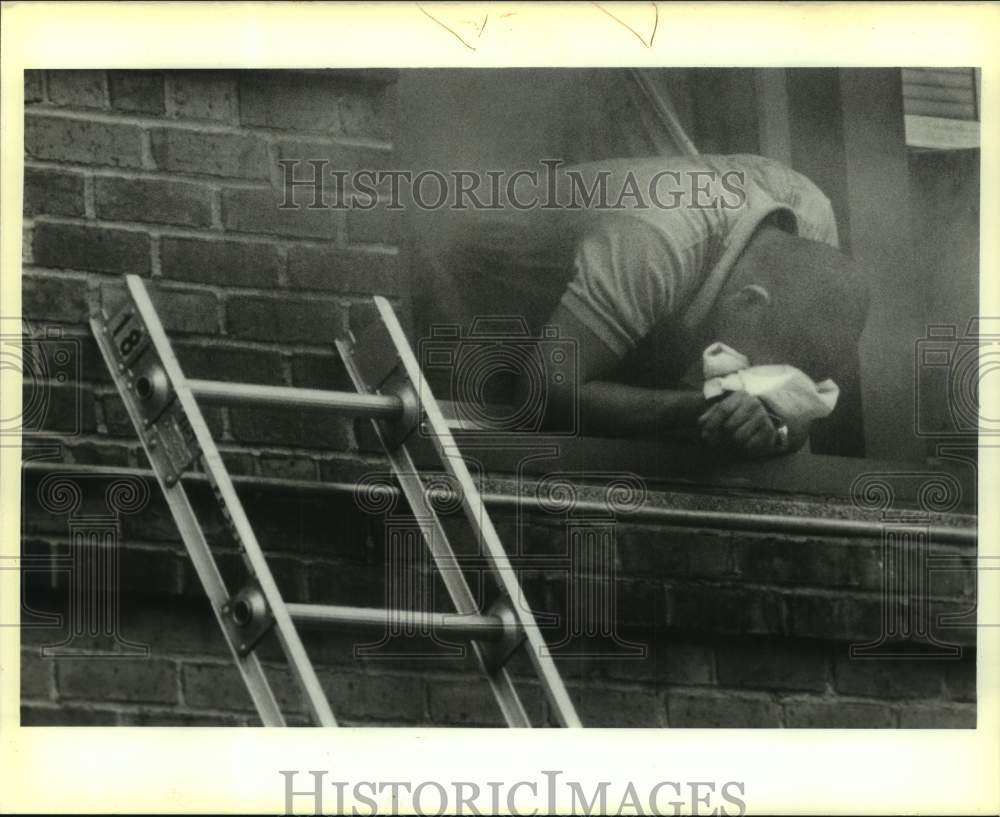 1988 Press Photo Michael Henderson overcome by fire smoke at 4004 Gibson Street - Historic Images