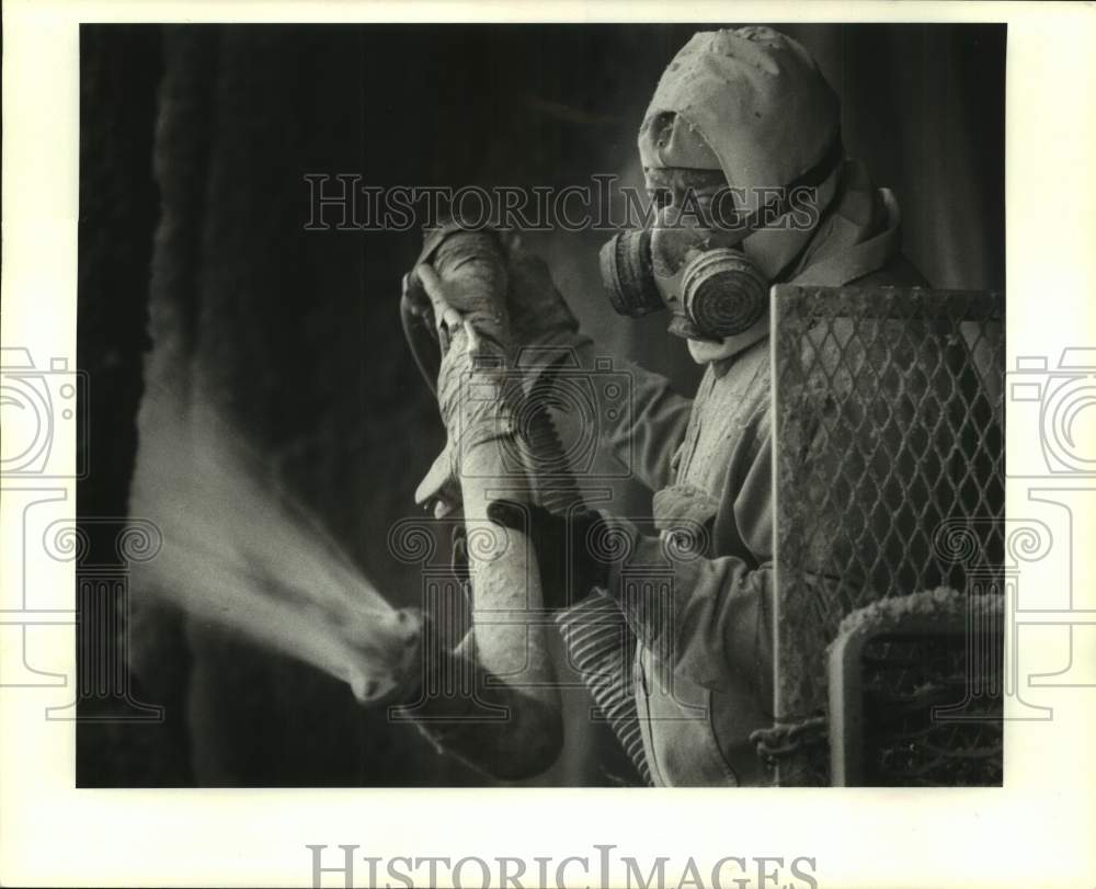 1987 Press Photo Joe Brand sprays fiberglass insulation on new Macy&#39;s Building - Historic Images