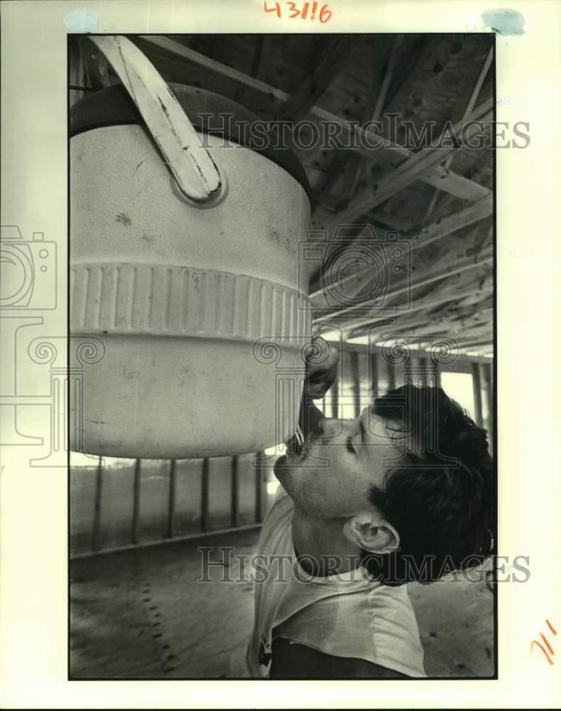 1988 Press Photo Henry Maitre drinks water while working as carpenter in Meraux - Historic Images