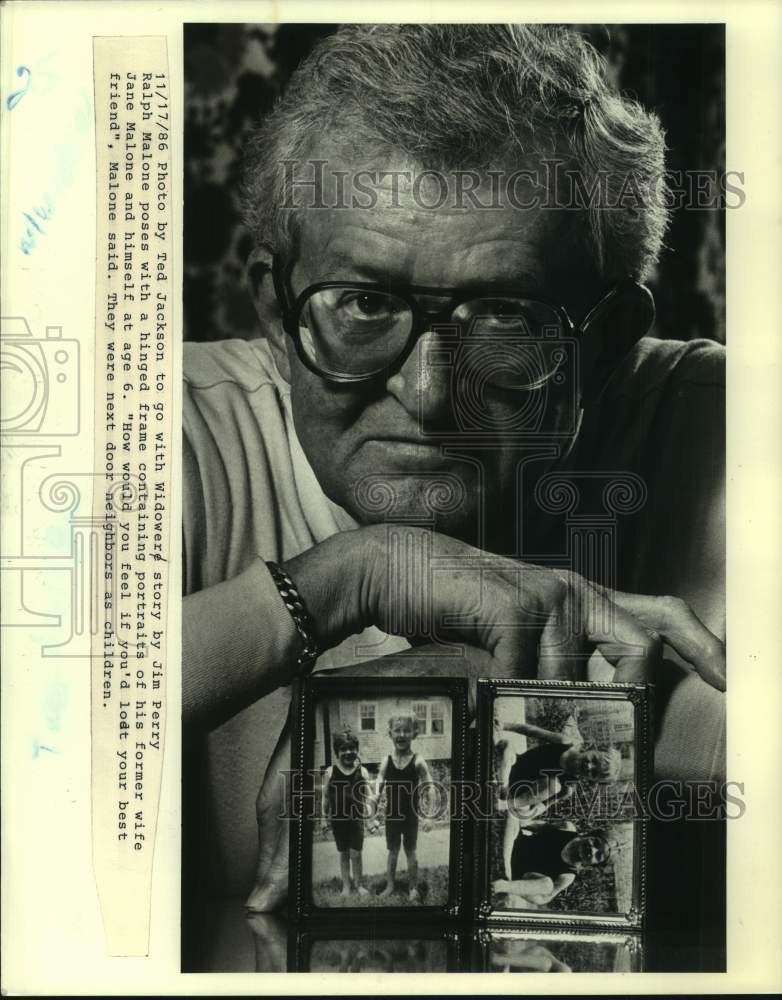 1986 Press Photo Ralph Malone poses with hinged frame of portraits of his wife - Historic Images