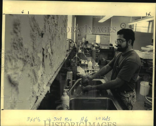 1992 Press Photo Nathan Manelkar cleans off glass jars at his lab at LSU - Historic Images