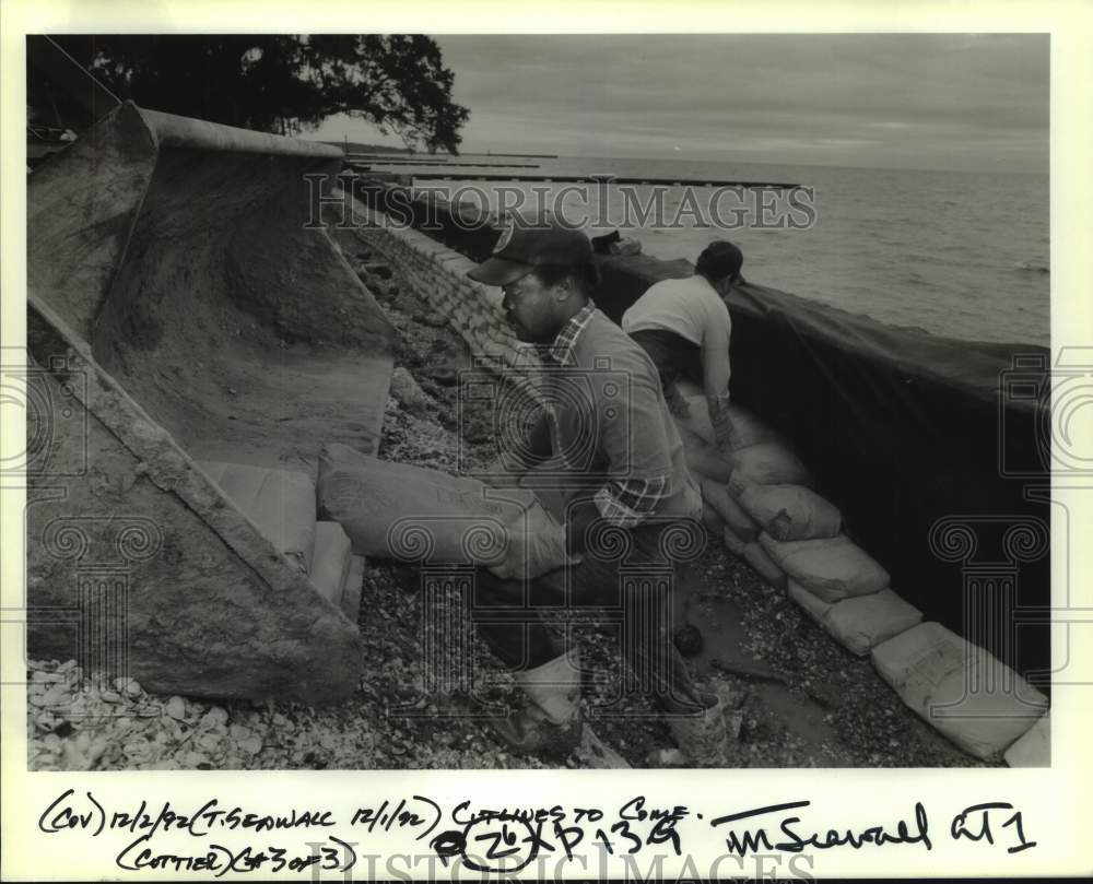 1992 Press Photo Workers put sandbags along the Mandeville Seawall - Historic Images