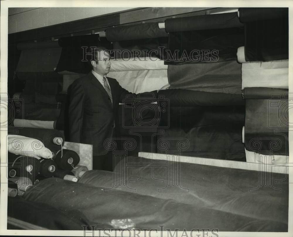 1970 Pat Marion checks a roll of fabric - Historic Images