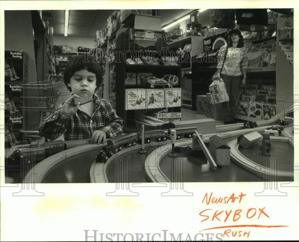 1987 Press Photo A child playing with model trains at Le Jouet Toystore Metairie - Historic Images