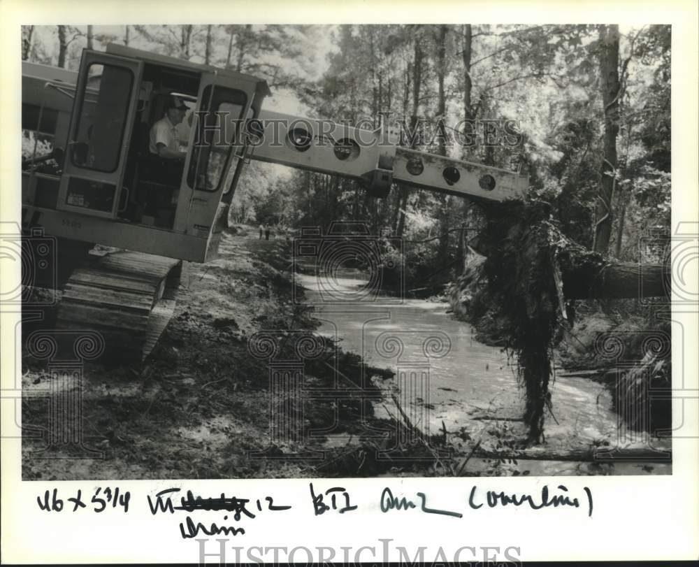 1989 Press Photo Wilson Jenkins uses Gradall machine to remove a tree from ditch - Historic Images