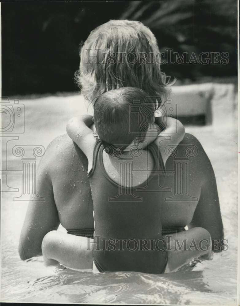 1973 Press Photo Baby Rides On Teachers Back During Swim Lessons For Children- Historic Images