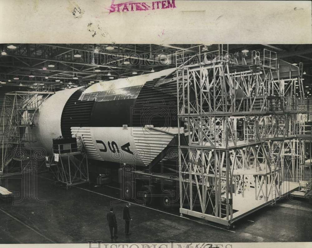 1966 First stage rocket booster dwarfs men at Michoud Assembly Plant - Historic Images