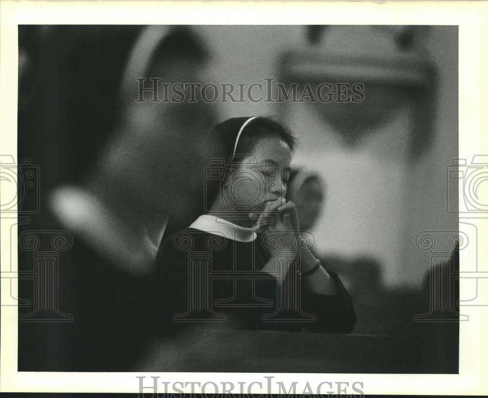 1989 Sister M. Martin Thienan prays during morning mass - Historic Images