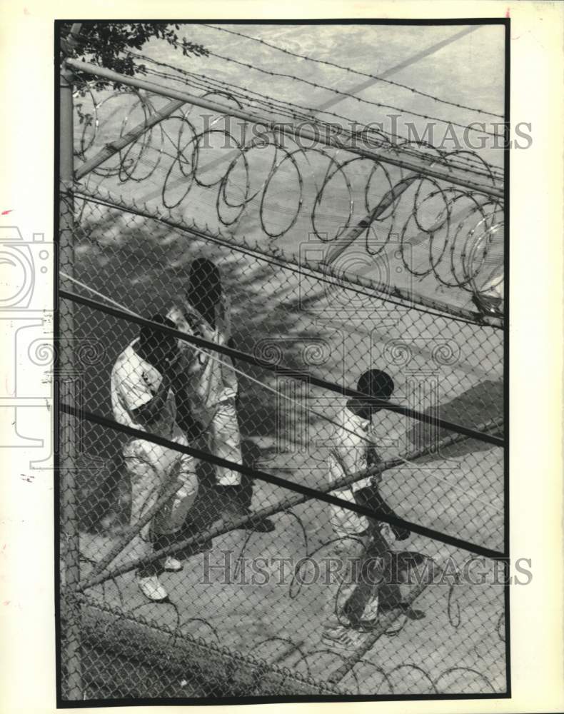 1989 Orleans parish prisoners walk in circle inside the prison fence-Historic Images