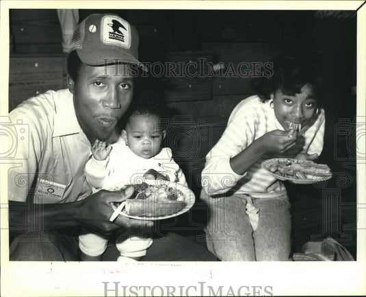 1988 U.S. Mailman, Milton Perkins sits with children & plate of food - Historic Images