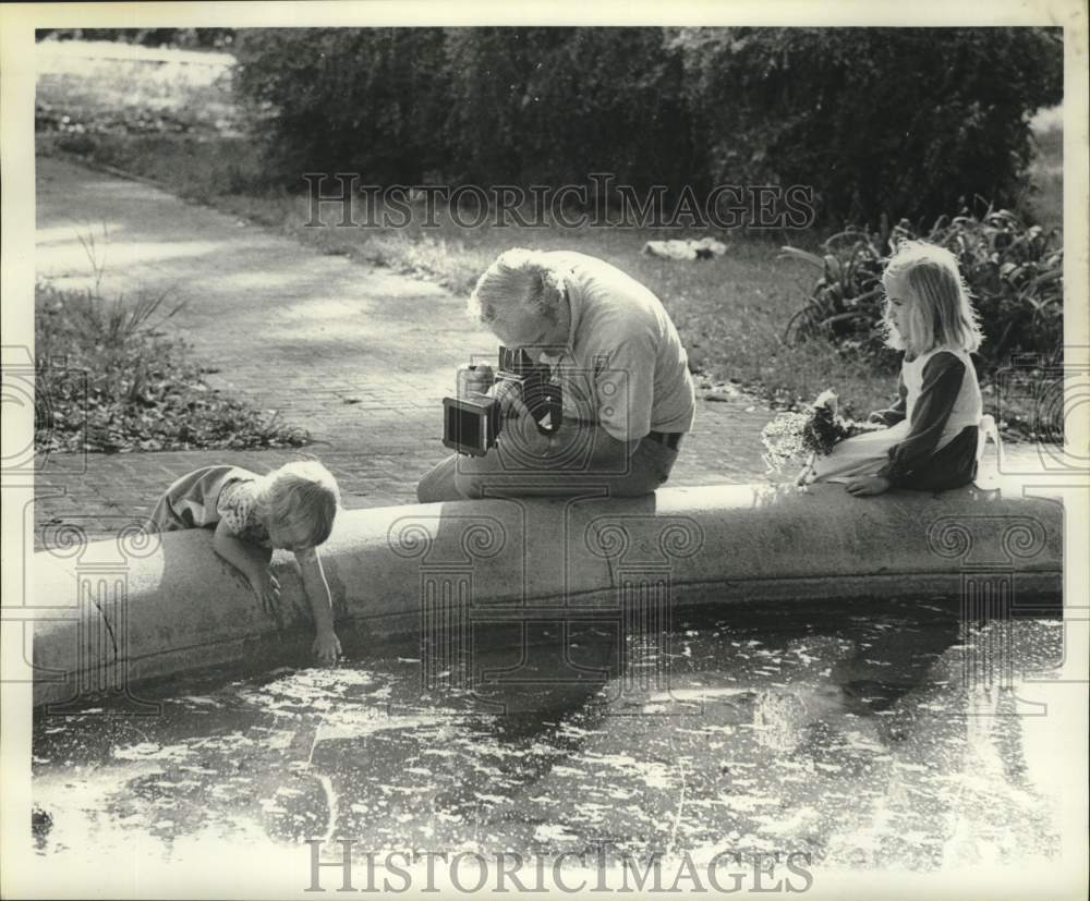 1976 Photographer Mike Posey with young subjects at the park - Historic Images