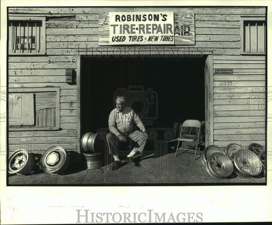 1988 Louis Robinson sits by his tire repair business in Louisiana - Historic Images