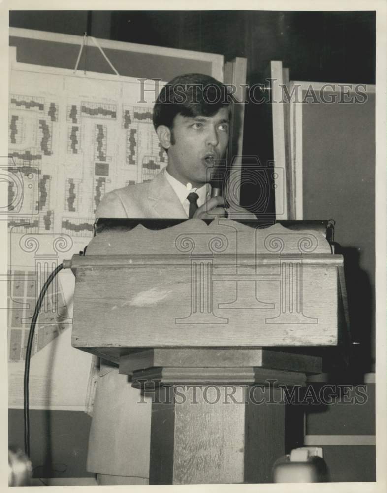 1968 John Pecoul stands at podium - Historic Images