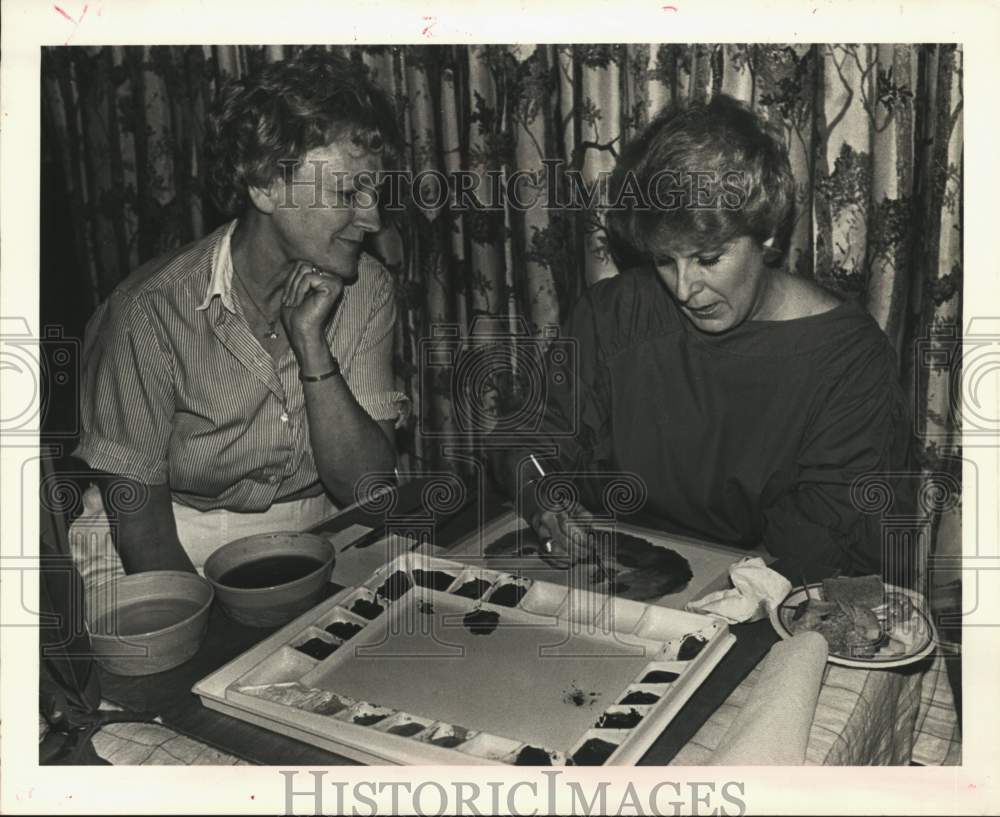 1985 St. Bernard Art Guild Zita Waller watches Claire Pescay paint - Historic Images