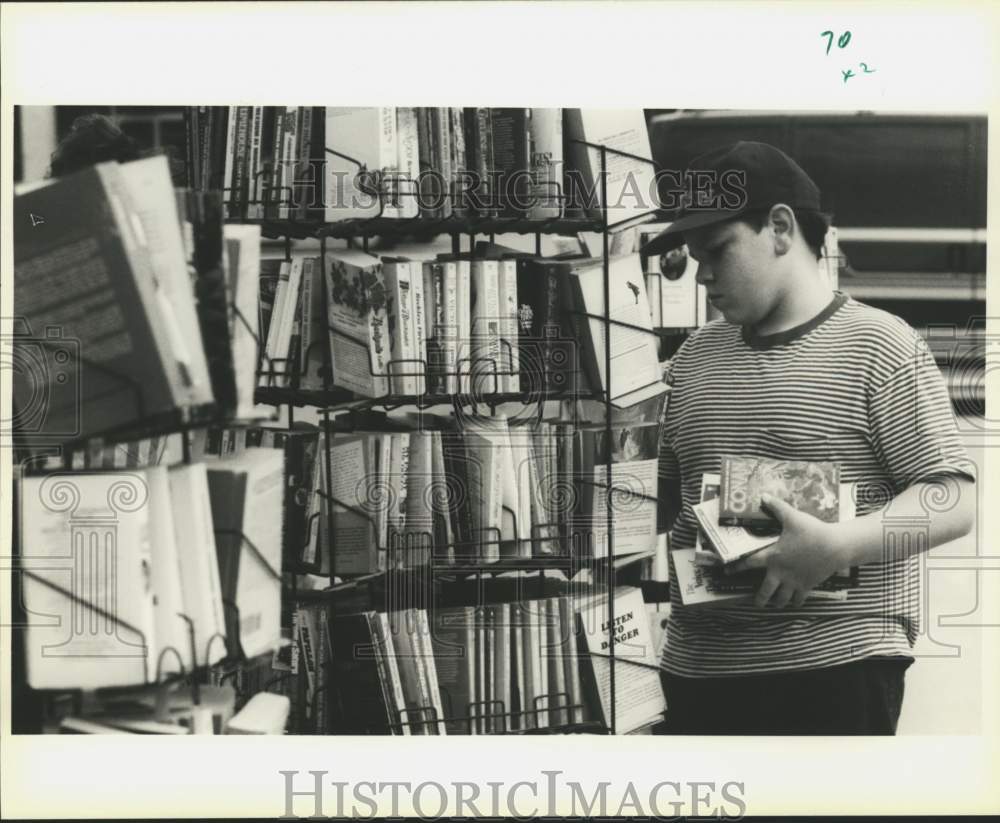 1994 Jessie Duhon looks through St. John Parish Library books sale - Historic Images