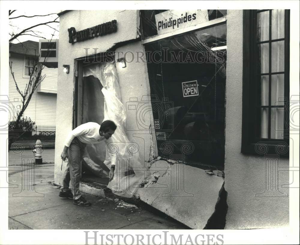 1986 Howard Heno checks his store where car plowed during robbery - Historic Images