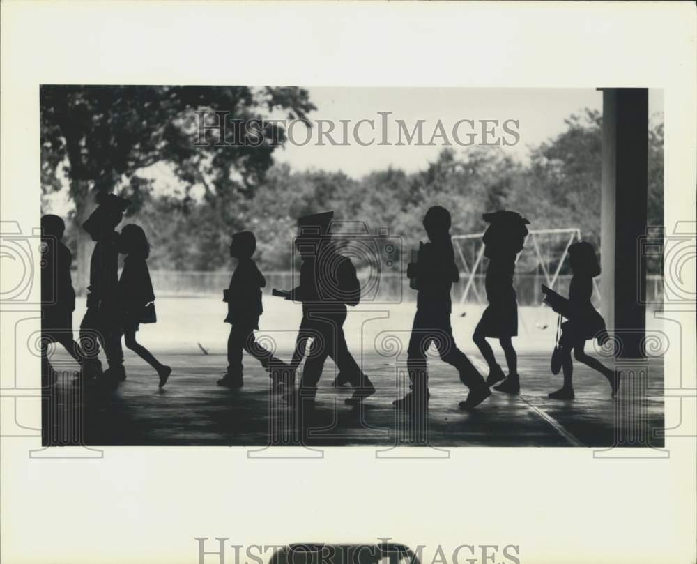 1990 Sebastien Roy School students walk to catch bus - Historic Images