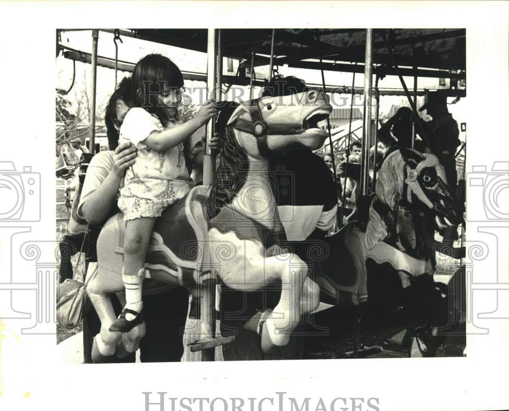 1988 Tabitha Stone rides Flying Horses at Riverdale High&#39;s fair. - Historic Images