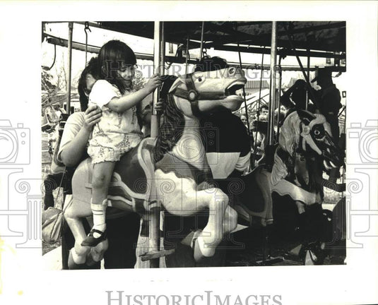1988 Tabitha Stone rides Flying Horses at Riverdale High's fair. - Historic Images