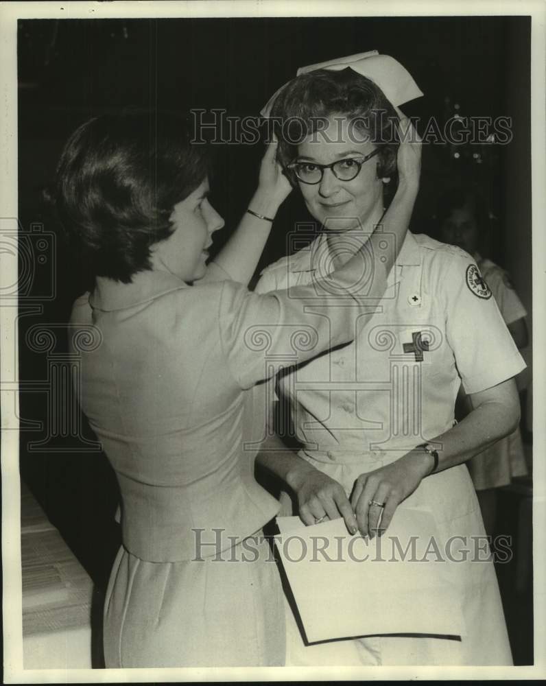 1964 Press Photo Mrs. George Munson places cap on Mrs. Emily Samuels, Red Cross - Historic Images