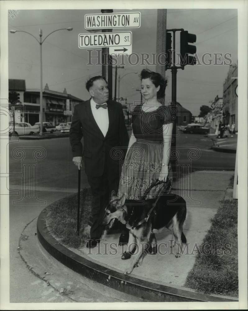 1961 Man approaches Blind Woman with Seeing Eye Dog at Street Corner - Historic Images