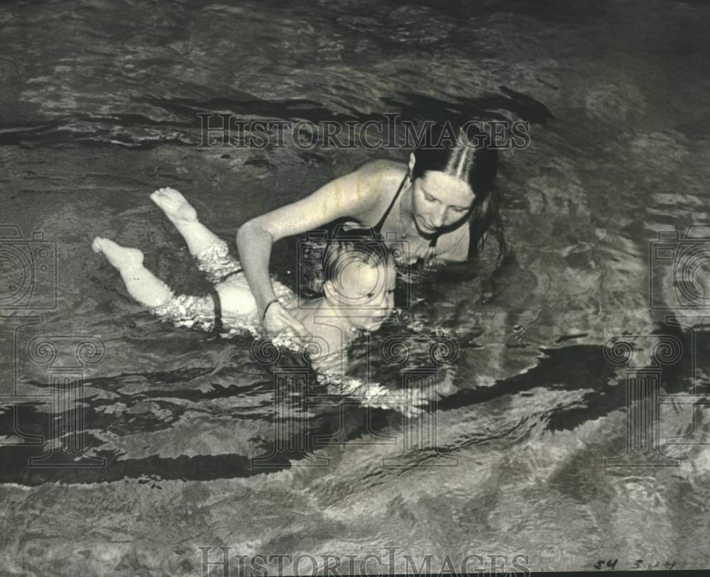 1981 Press Photo Woman helps Child swim through water at YMCA - noc40982 - Historic Images