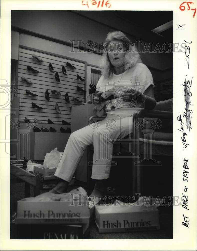 1988 Zena Shine fitting shoes at Kraus Co. shoe department - Historic Images