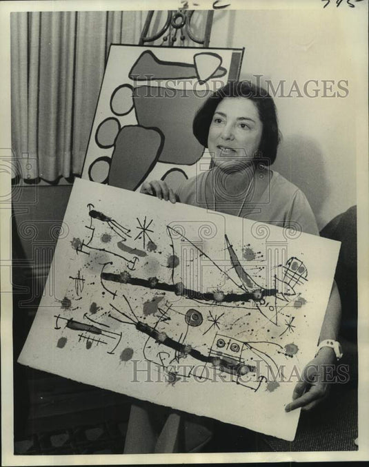 1975 Mrs. Joel Weinstock is holding an original Miro lithograph. - Historic Images