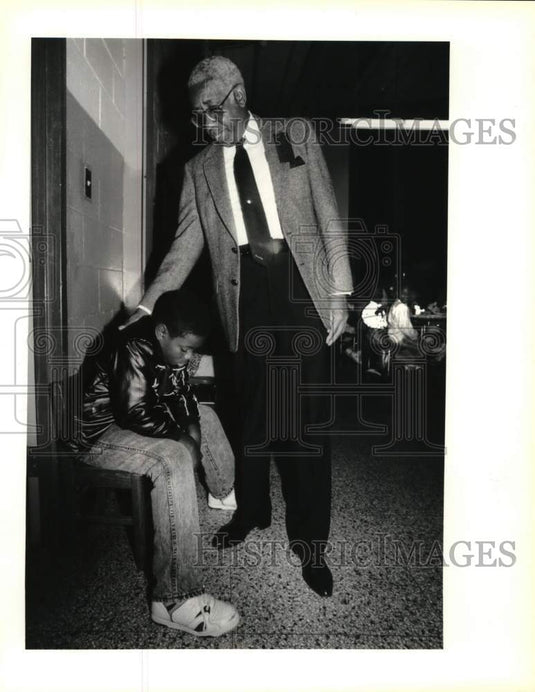 1990 Principal Prince Washington encourages sick student - Historic Images