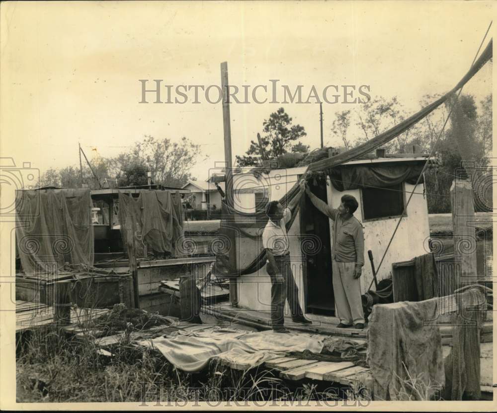 1961 Press Photo Martin Molero inspects a net on George I. Trosclair shrimp boat - Historic Images