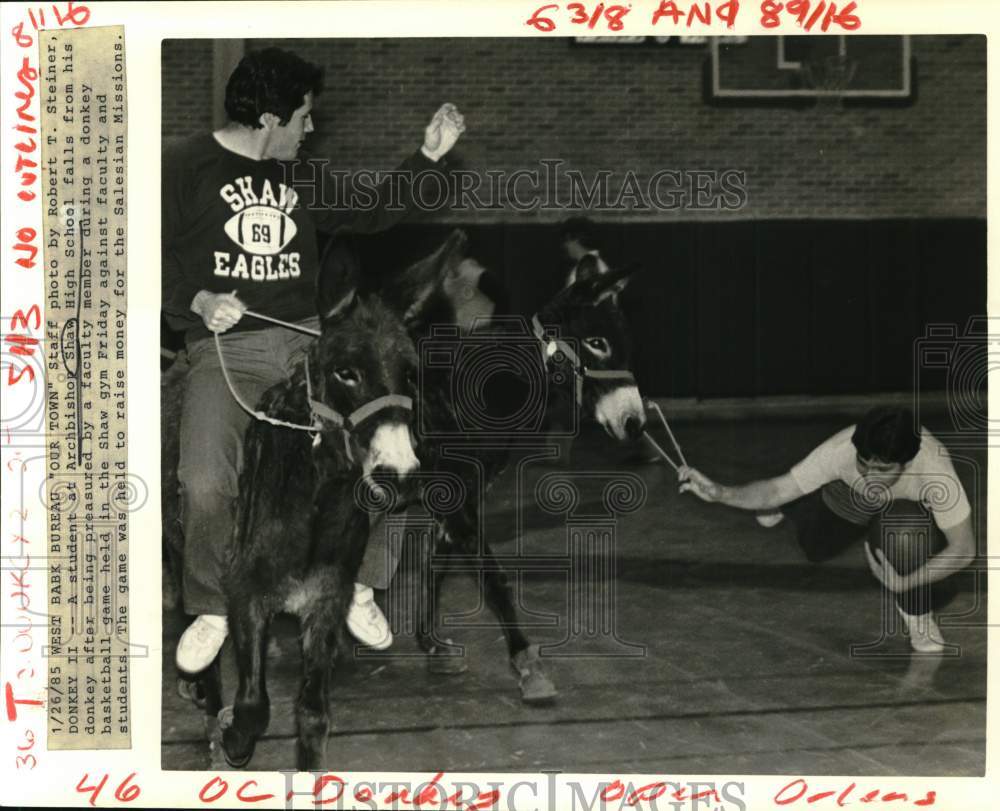 1985 Student at Archbishop Shaw falls from his donkey during a game. - Historic Images