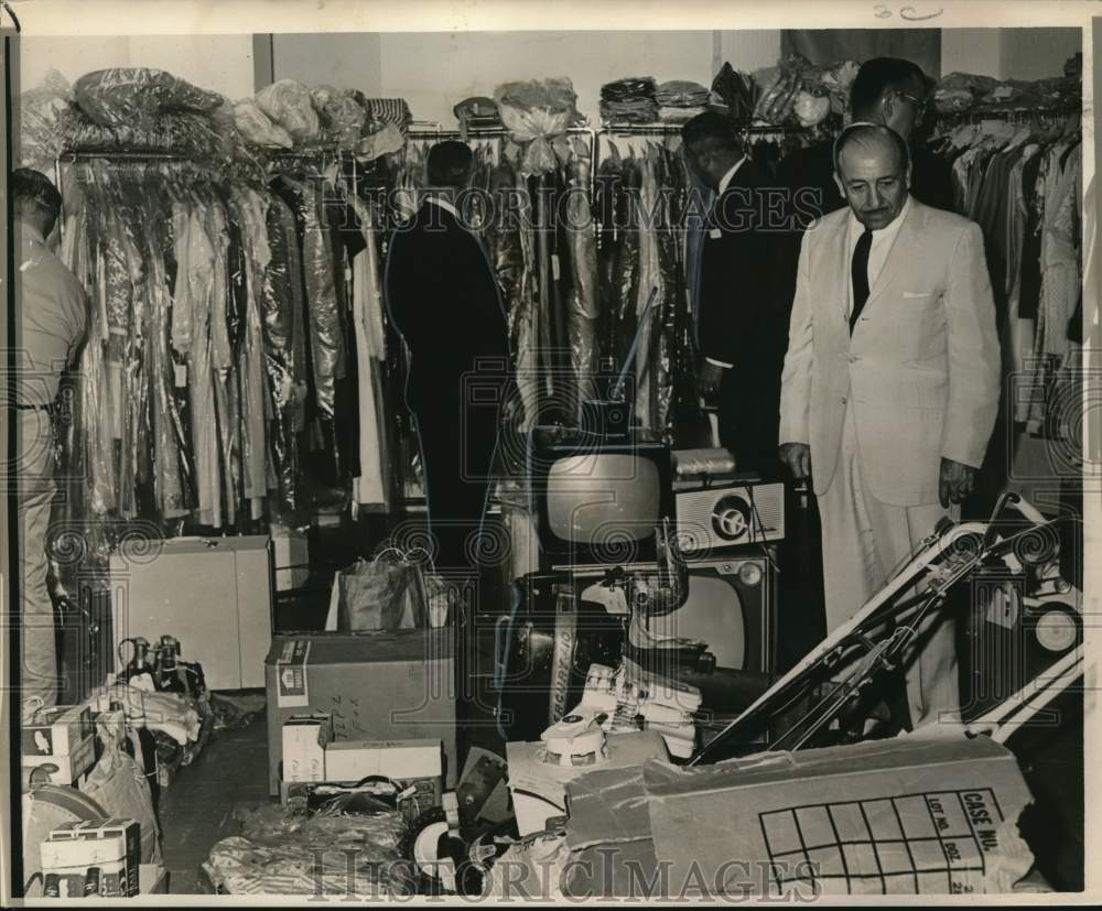 1964 Mayor Victor H. Schiro examines seized stolen merchandise - Historic Images