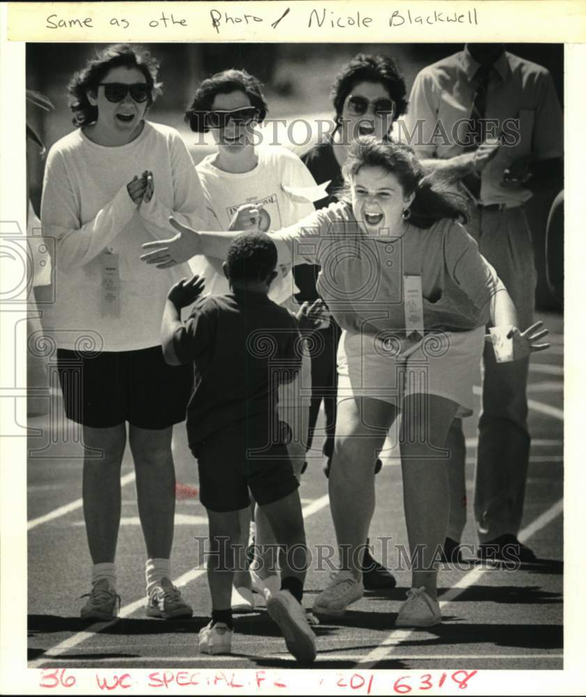 1988 Press Photo Nicole Blackwell in Special Olympics welcoming runner. - Historic Images