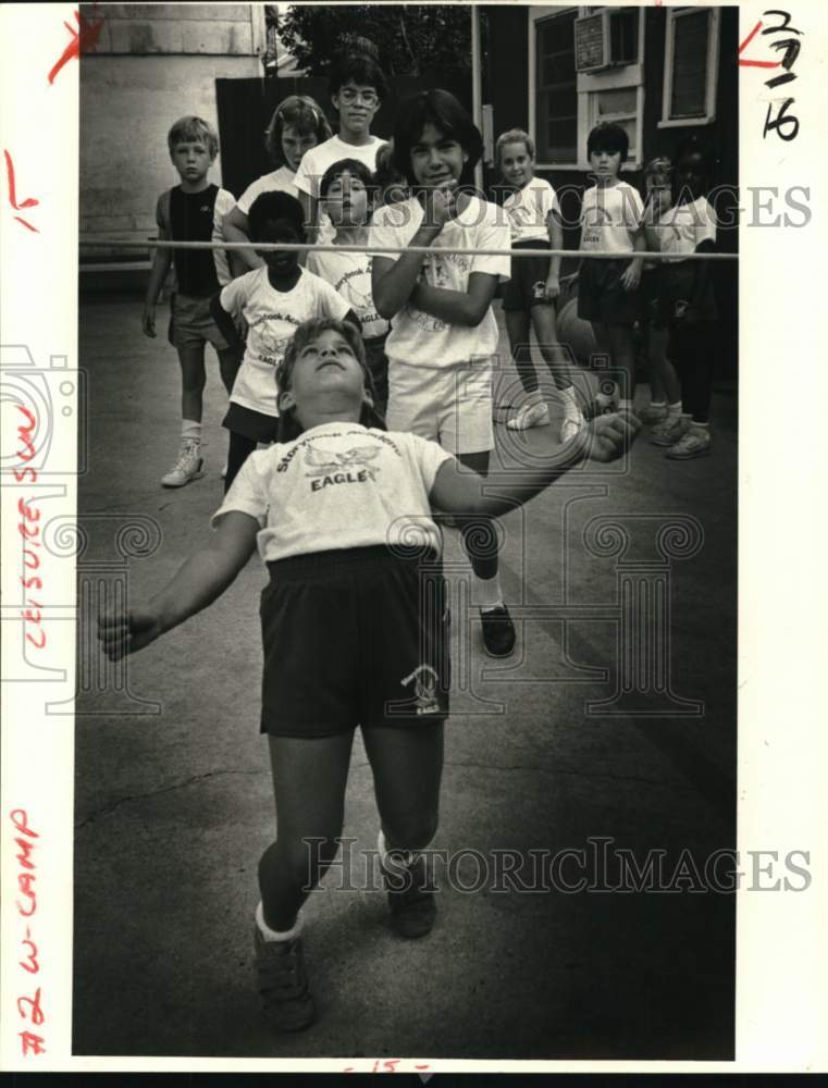 1985 Katie Barber does the limbo at the Story Book Academy camp. - Historic Images