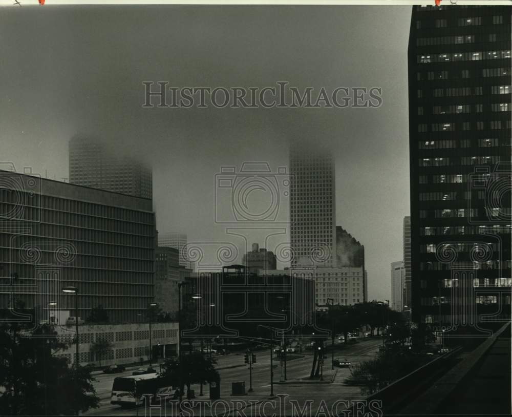 1984 Top of buildings in Central Business District fade into clouds - Historic Images